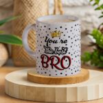 You're the Best Bro Raksha Bandhan Gift Set – White Ceramic Mug with Black Dots, OM Rakhi on Cushion, and Matching Coaster by The Crafted Joy